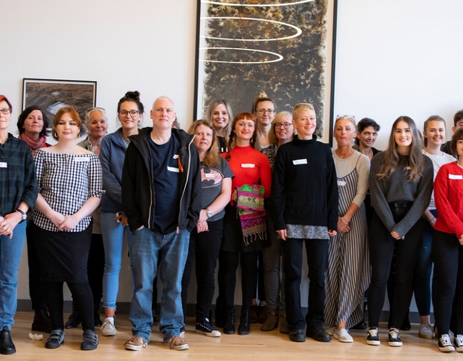 Group of people standing in front of art Group of people standing in front of art