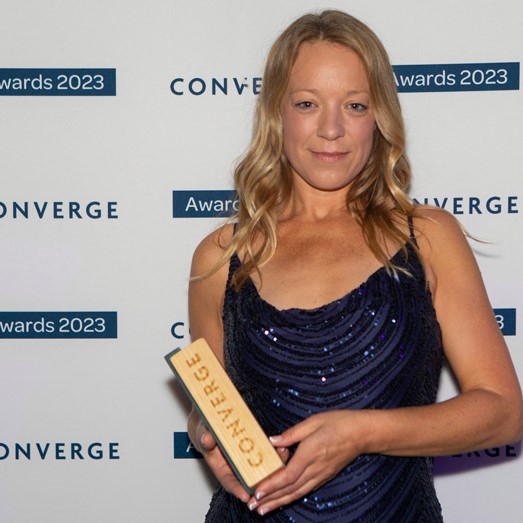 Dr Georgina Robinson holding wooden trophy from Converge Dr Georgina Robinson holding wooden trophy from Converge