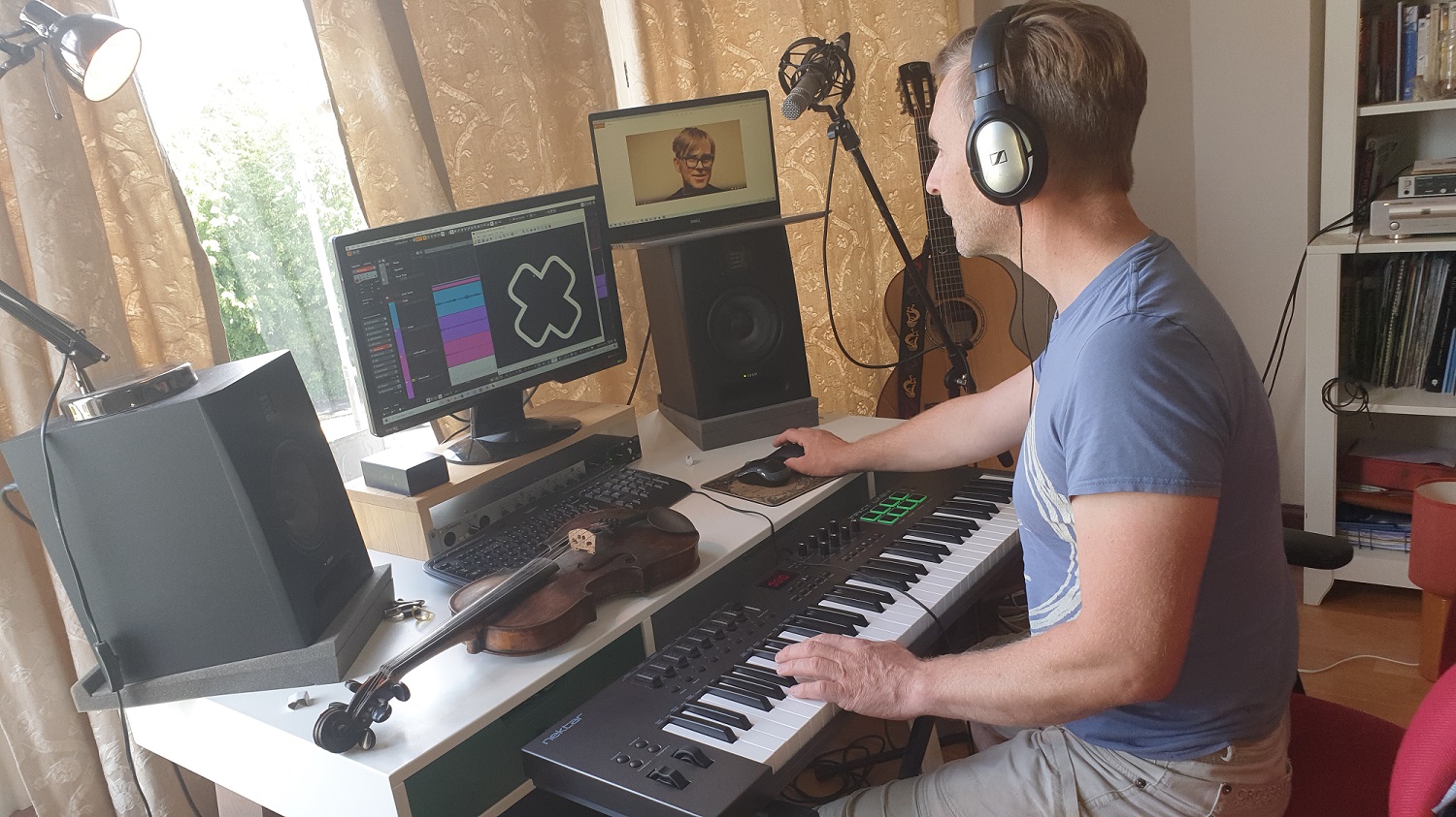 person with headphones using keyboards, computer screens person with headphones using keyboards, computer screens