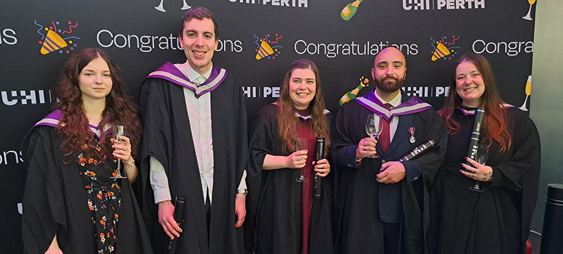 UHI Perth graduates posing in gowns UHI Perth graduates posing in gowns