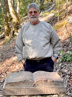 Lecturer Jimm Simon standing behind Robert Louis Stevenson memorial Lecturer Jimm Simon standing behind Robert Louis Stevenson memorial