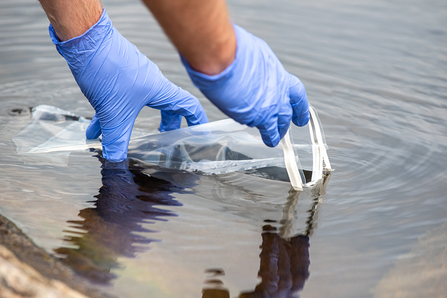 Person taking a water sample Person taking a water sample