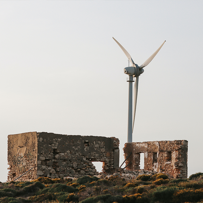 Wind turbine next to broken down building. Wind turbine next to broken down building.